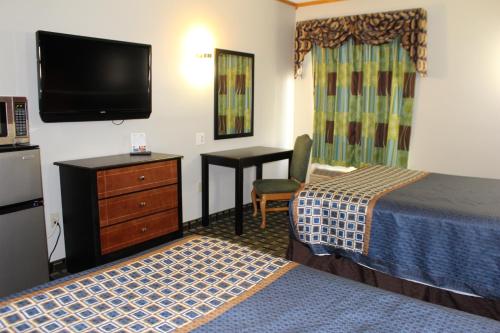 a hotel room with two beds and a flat screen tv at Home Gate Inn & Suites in Southaven