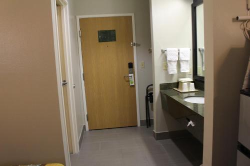 een badkamer met een wastafel en een houten deur bij Home Gate Inn & Suites in Southaven