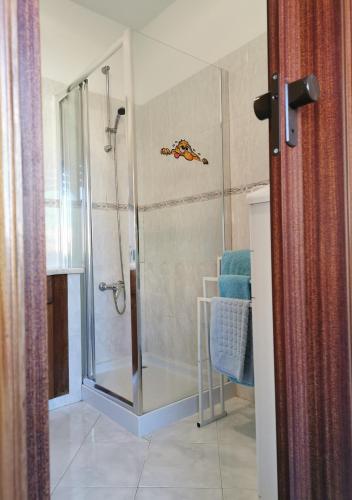 una doccia con porta in vetro in un bagno di Edificio Lavadeiras a Olhão