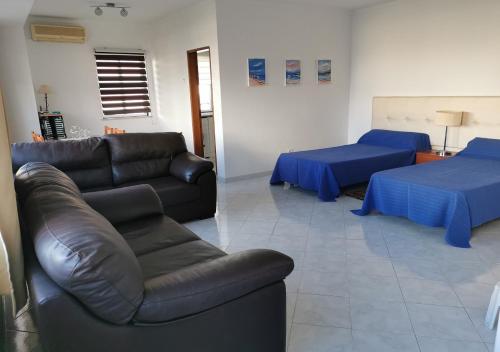 een woonkamer met 2 bedden en een bank bij Edificio Lavadeiras in Olhão