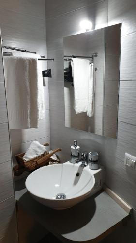 W łazience znajduje się umywalka, lustro i ręczniki. w obiekcie B&B Vesuvio Ruins w mieście Pompeje