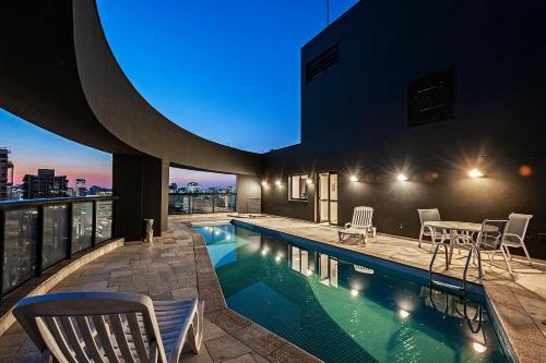 a pool on the roof of a building at night at Slaviero São Paulo Moema in Sao Paulo