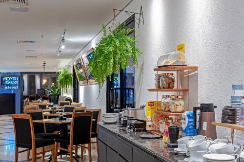 a restaurant with a counter with chairs and tables at Slaviero São Paulo Moema in Sao Paulo