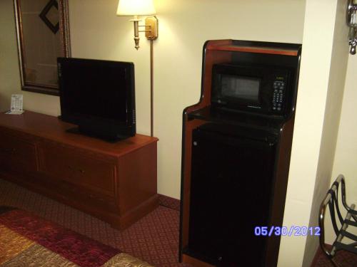 a hotel room with a microwave and a television at All American Inn & Suites Branson in Branson