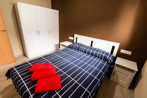 a bedroom with a blue and red bed with red pillows at CASA CAL METGE in Benissanet
