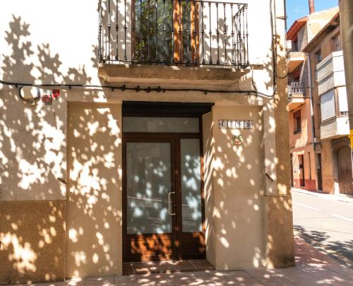 a building with a door and a balcony at CASA CAL METGE in Benissanet