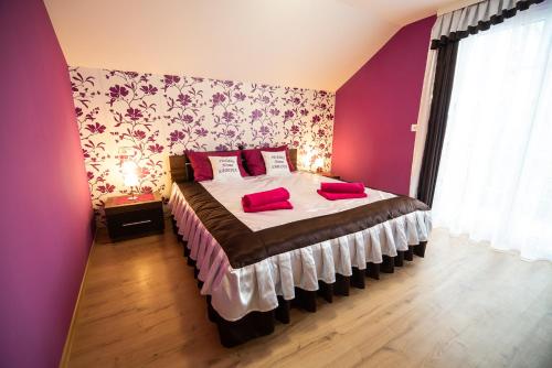 a bedroom with a bed with red pillows on it at Holiday Home with Hot tub and Sauna Sabina in Rovte
