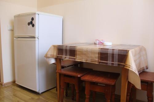 a kitchen with a table and a refrigerator at Apartments Domovik ,Kirilla i Mefodiya, 5 in Mukacheve