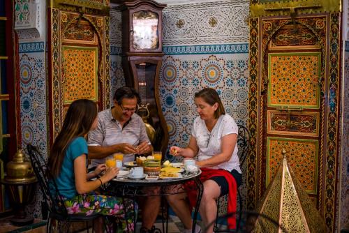 een groep mensen die aan een tafel eten bij Riad Royal in Meknès