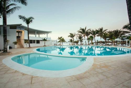 uma grande piscina com palmeiras e um edifício em apartamento superamplio con la mejor vista al mar solo adultos em La Laguna