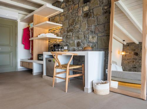 eine Küche mit einem Tisch und einer Steinmauer in der Unterkunft Hotel Milos Sea Resort in Adamas