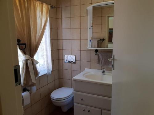 a bathroom with a toilet and a sink and a mirror at Accommodation@Bourne in Centurion