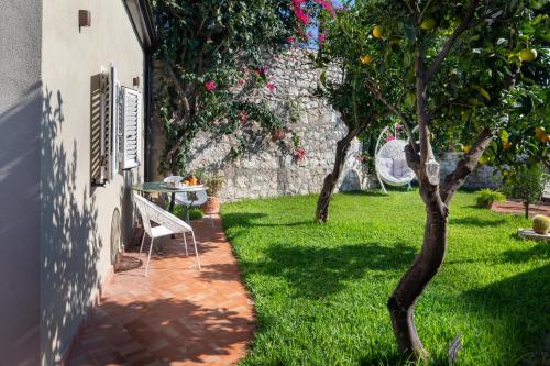 a garden with an orange tree and a table at Hotel Villa Taormina in Taormina