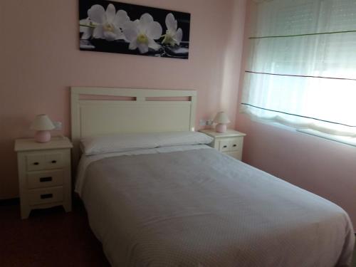 レス・カセス・ダルカナールにあるApartamento Lepanto Playaのベッドルーム1室(白いベッド1台、ナイトスタンド2台付)