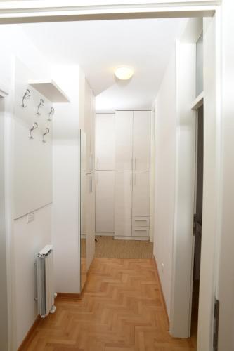um corredor com paredes brancas e pisos de madeira em Zap apartman em Belgrado