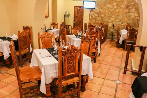 a dining room with tables with white tablecloths at Hotel Agua Escondida in Taxco de Alarcón