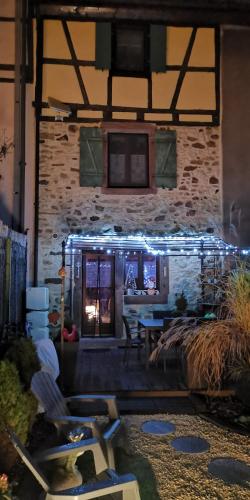 a building with a stone wall with a patio at GITE LE COQ ROUGE in Eguisheim