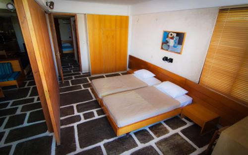 a bed in a room with a wooden floor at Apollonia Hotel Apartments in Varkiza