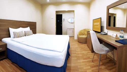 コヴロフにあるEverest Comfortの大きなベッドとデスクが備わるホテルルームです。