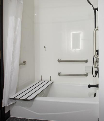 a bathtub with a bench in a bathroom at TRYP by Wyndham Pittsburgh/Lawrenceville in Pittsburgh