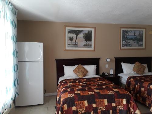 a hotel room with a bed and a refrigerator at Budget Lodge Mount Dora in Mount Dora