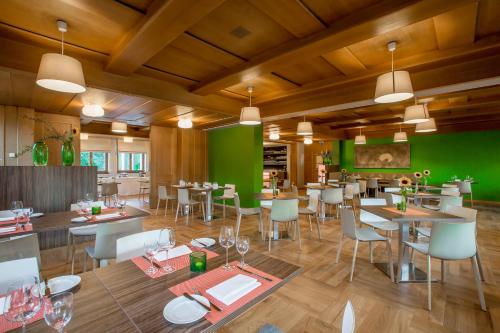 a restaurant with tables and chairs and green walls at Hotel Parsberg in Puchheim