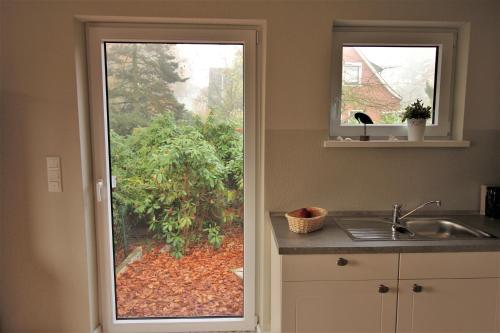 a kitchen with a door leading to a garden at Stadtwohnung zur großen Buche, EG in Leer