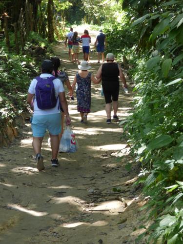 a group of people walking down a dirt trail at Hostal Alto de la Montaña in Minca