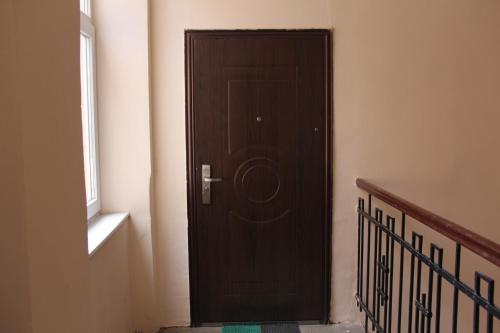 a wooden door in a room with a staircase at Apartments Domovik ,Kirilla i Mefodiya, 5 in Mukacheve