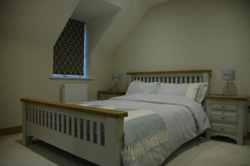 a bedroom with a large bed and a window at The Final Furlong, Bruton in Bruton