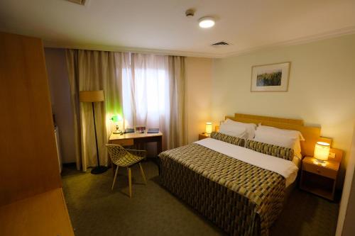 a hotel room with a bed and a desk at Royal Court Hotel in Ramallah