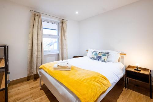 ein Schlafzimmer mit einem Bett mit einer gelben Decke darauf in der Unterkunft Three Tuns Apartments - Sycamore in Pettistree