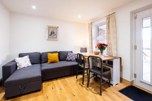 a living room with a couch and a table at Three Tuns Apartments - Sycamore in Pettistree