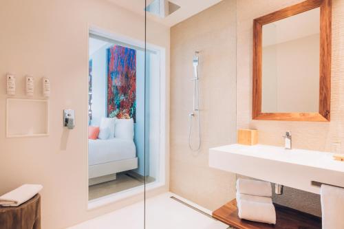 a bathroom with a shower and a sink and a mirror at Iberostar Selection Coral Cancun - Adults Only All Inclusive Resort in Cancún