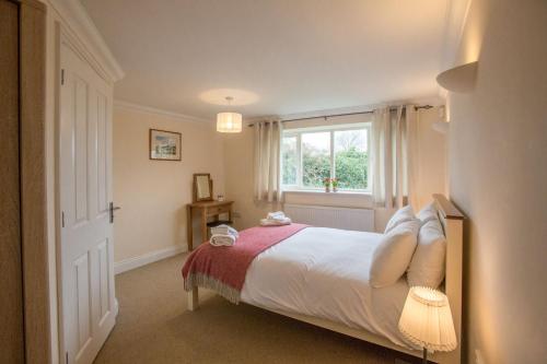 ein Schlafzimmer mit einem großen Bett und einem Fenster in der Unterkunft 2 Hazelwood in Aldringham