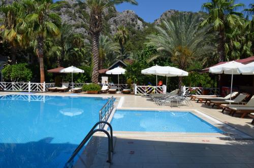 a swimming pool with chairs and umbrellas in a resort at Aida Hotel in Cıralı