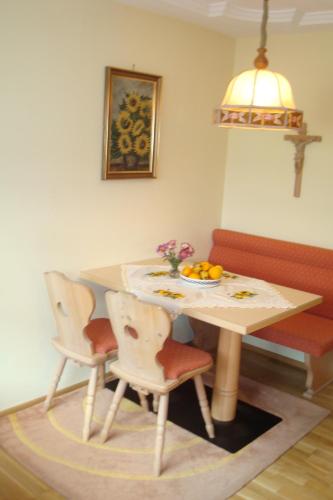 a table and chairs with a bowl of fruit on it at Gästehaus Moser in Ramingstein