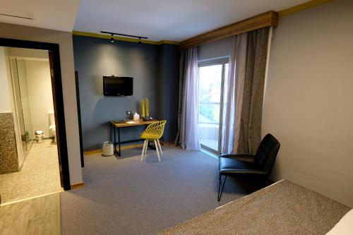 a room with a chair and a table and a window at Royal Court Hotel in Ramallah