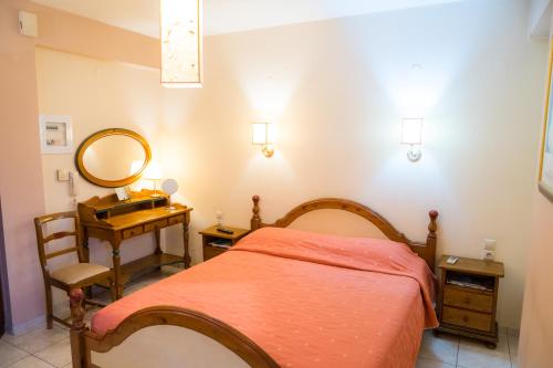 a bedroom with a bed and a vanity and a mirror at Yiannis Apartments in Ioannina