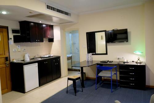 a kitchen with a table and a sink and a counter at Royal Court Hotel in Ramallah