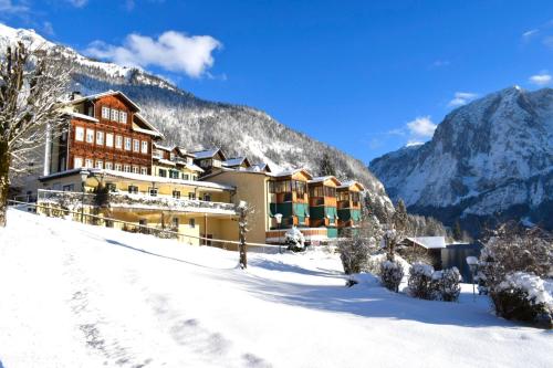 a hotel in the mountains in the snow at Hotel am See - Seeresidenz in Altaussee