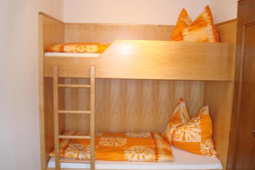 two bunk beds with orange pillows in a room at Gästehaus Moser in Ramingstein