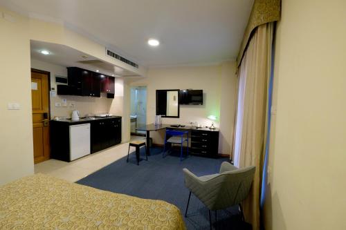 a room with a bed and a kitchen with a table at Royal Court Hotel in Ramallah