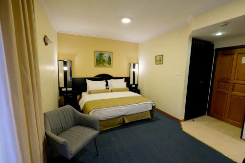 a hotel room with a bed and a chair at Royal Court Hotel in Ramallah