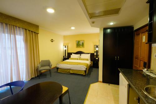 a hotel room with a bed and a kitchen at Royal Court Hotel in Ramallah