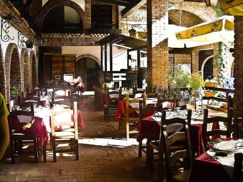 a restaurant with tables and chairs in a brick building at Hotel Restaurant Bujtina e Gjelit in Tirana