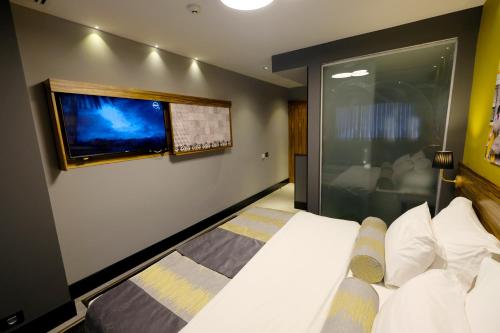 a bedroom with a bed and a flat screen tv at Royal Court Hotel in Ramallah
