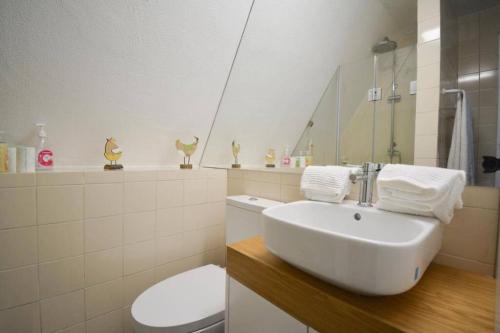 Un baño con un inodoro blanco y un lavabo. en Chalé Acolhedor - Penhas da Saúde - Serra da Estrela, en Covilhã
