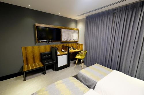 a hotel room with a bed and a desk with a computer at Royal Court Hotel in Ramallah
