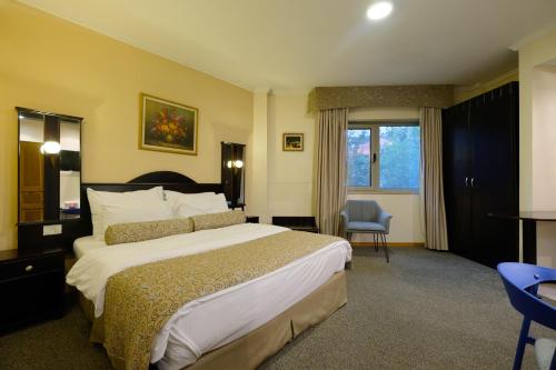 a hotel room with a large bed and a chair at Royal Court Hotel in Ramallah